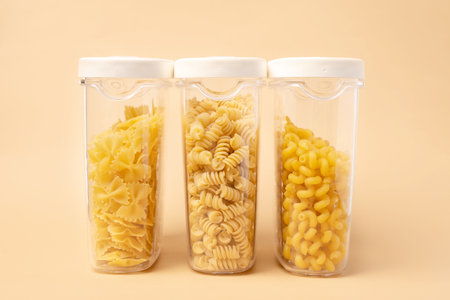 Different types of pasta in containers on a beige backgroundの写真素材