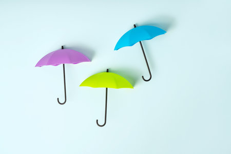Colored umbrellas on a blue background. Conceptuality and place for the textの写真素材