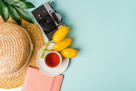 A notebook, a mug of tea, and flowers on the blue table. The concept of spring mood and travelの写真素材