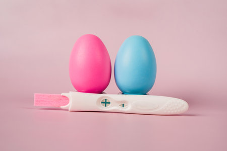 A positive pregnancy test on a pink background and pink and blue eggs, determining the gender of the unborn childの写真素材