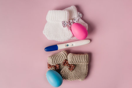 A positive pregnancy test on a pink background and pink and blue eggs, determining the gender of the unborn childの写真素材