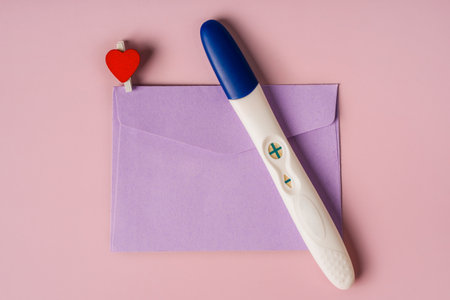 A positive pregnancy test in an envelope. Pregnancy message concept, good newsの写真素材
