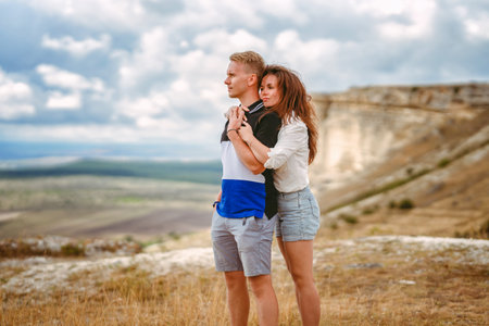 A man and a woman in love embrace on the edge of a cliff with a view of the White Rock and the surrounding area in the Crimea. The concept of joint travel.の写真素材