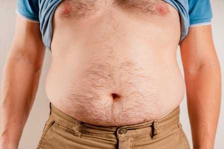 Overweight obese man showing his big bare bellyの写真素材