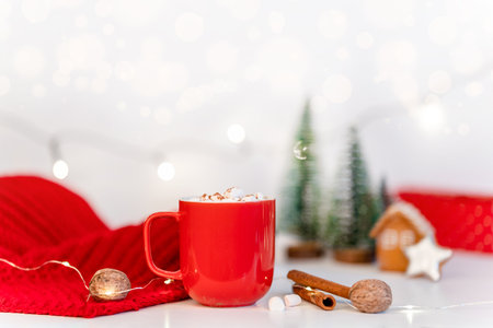 Beautiful Christmas background with cocoa mug, garland and red scarf. Holiday atmosphere of a winter eveningの写真素材