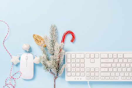 Christmas home office desk with keyboard, pine branches and Christmas items on a blue background. Flat layout, top view, copy spaceの写真素材