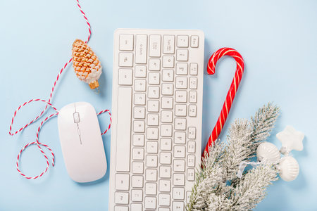 Christmas home office desk with keyboard, pine branches and Christmas items on a blue background. Flat layout, top view, copy spaceの写真素材