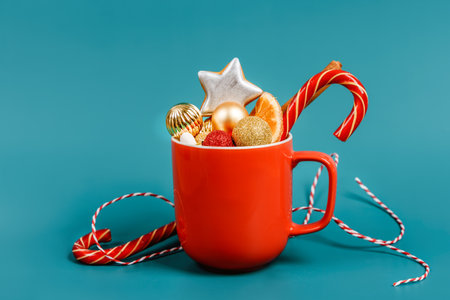 Christmas composition with holiday decorations in a red mug. Minimalistic background with space for text. Christmas cardの写真素材