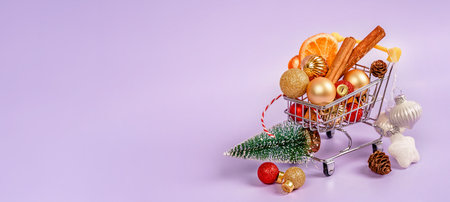 A cart with Christmas decorations on a purple background. The concept of buying gifts for the new year and Christmasの写真素材