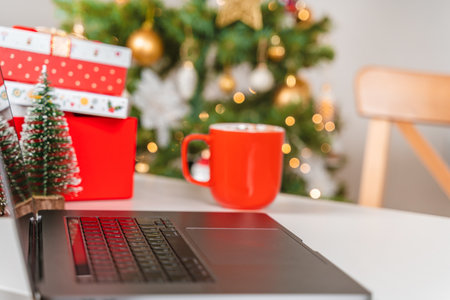 Selective focus on laptop keyboard with Christmas tree backgroundの写真素材