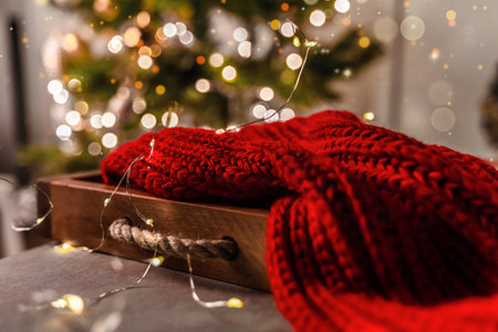 Cozy Christmas card with a red plaid and a decorated tree in the living room of the houseの写真素材