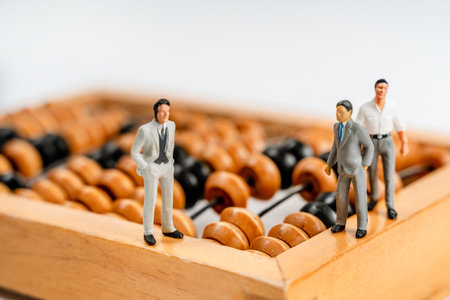 Miniature figures of businessmen stand on a calculator to calculate profits. The concept of business and making moneyの写真素材
