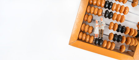 Miniature figures of people an elderly couple grandmother and grandfather stand on wooden abacus to...