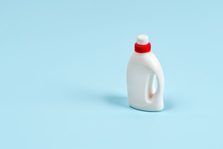 A bottle of cleaning agent on a blue background. An object in minimalism