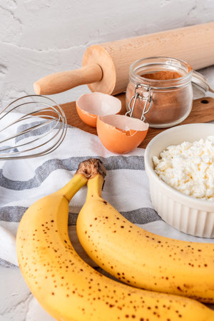 Baking homemade sweets on white table with ingredients for cooking, culinary background, copy space, overhead viewの写真素材