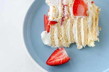 Delicious cake with cream cheese and strawberries. Beautiful serving on a white brick background