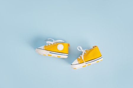 Baby's little sneakers on a colorful background. The concept of waiting for a baby and the concept of traveling with baby, children's lifestyle. Copy space, flat layの写真素材