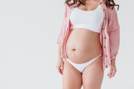 A gentle elegant pregnant woman with big belly, mother waiting for a babyの写真素材