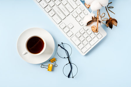 office desk, minimalist style desk with keyboard, tea mug and glasses, copy space, top view, flat layout, layoutの写真素材