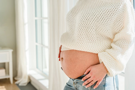 A beautiful pregnant young woman with a big belly and a bouquet of tulips. Colorful spring pregnancy concept, bannerの写真素材