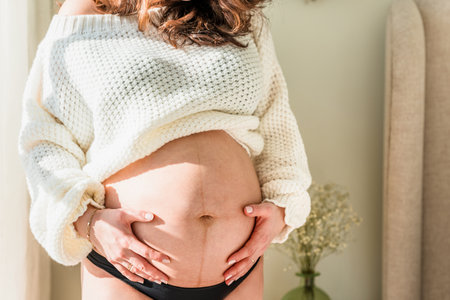 A beautiful pregnant young woman with a big belly and a bouquet of tulips. Colorful spring pregnancy concept, bannerの写真素材