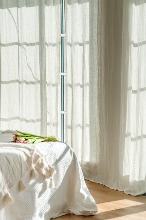 Spring concept with pink tulips lying on a blanket in a bright modern interior. A beautiful banner for spring and summer.の写真素材