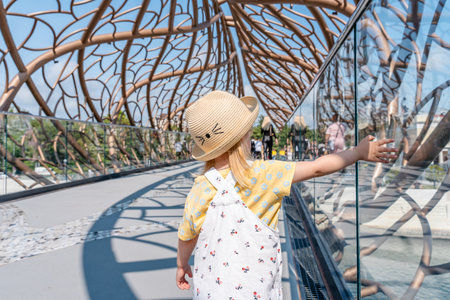 Child girl walks across an unusual pedestrian bridge