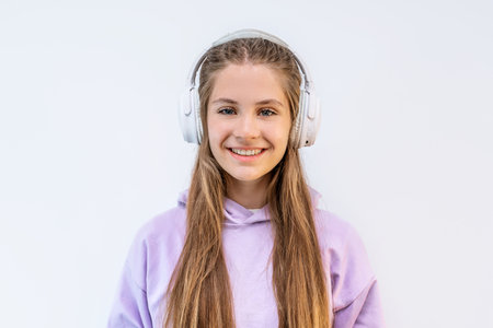 Attractive teenage girl in purple hoodie and headphones on isolated white background