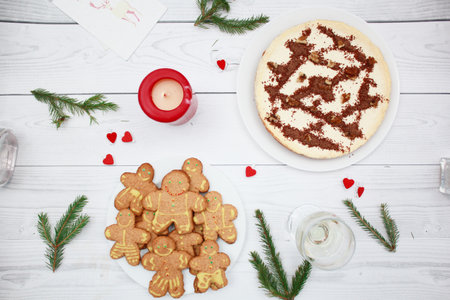 Cheesecake with chocolate on the wooden background top view. Fir branches. Christmas gingerbread man...