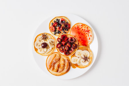 Baked pancakes or homemade cakes. On top is decorated with berries, fruits, honey and jam on rustic background. top view. close up. Chalk plaqueの写真素材