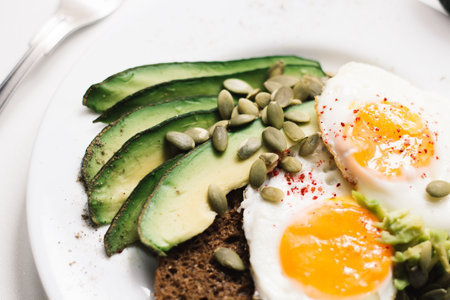 sandwich with fresh vegetables, avocado, hard-boiled eggs and pumpkin seeds with olive oil and bread. healthy diet or vegetarian food on a white background. salad with yolks on toast. top viewの写真素材