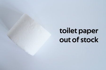 rolled white toilet paper on a white background and text toilet paper out of stock. ofl font. flat lay, top viewの写真素材