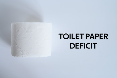 rolled white toilet paper on a white background and text toilet paper deficit. ofl font. flat lay, top viewの写真素材