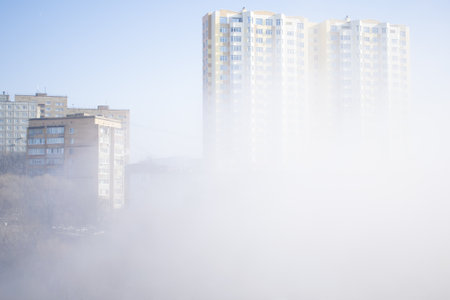 Morning fog among high buildings at residential district. Foggy urban scene.の写真素材
