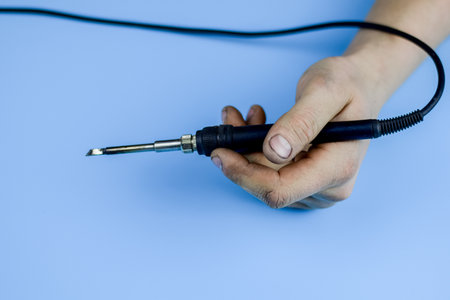 Soldering iron in a dirty working hand. Home work concept.の写真素材