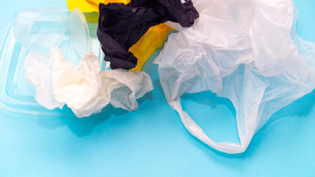 Caring for nature. Garbage collection, ecology, seasonal cleaning, recycling. Garbage from plastic, paper, iron, cellophane on a blue background. Selective focus. Place for text. Copy space.の写真素材