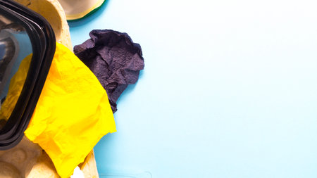 Garbage from plastic, paper, iron, cellophane on a blue background.の写真素材