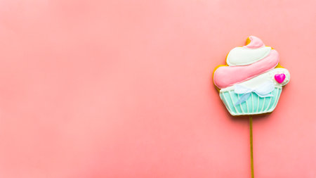 Gingerbread on a wooden stick in the form of a muffin on a pink background. Tasty treat for the...