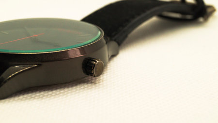 Black mens wristwatch with a red arrow on a white background. Clock without numbers. Mens accessory. Place for text. Side view.の写真素材