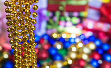 colored Christmas tree toys and golden beads are scattered on the table New Year's gifts and a box with toys for the Christmas tree on a green background. background for the holiday. New Year mood andの写真素材