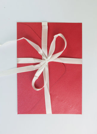 gift red envelope with a white bow. gift on a white background. give gifts for the holidays. celebrate .autumn holidays. background for blogの写真素材
