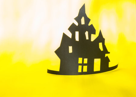 Halloween and decoration concept - bats, pumpkins, gloomy paper house, gloomy black tree branches on a yellow background. Folded paper origami art. Halloween background with cut out batsの写真素材