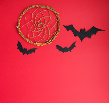 Halloween flat lay - bats and pumpkin on red background. gifts and shopping for halloween. place for text.holidays and surprises.の写真素材