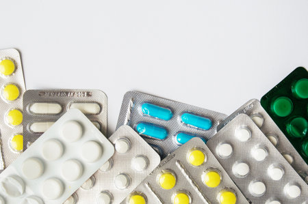 Medical mercury thermometer on the background of pills and a protective mask. Medicinal pills on a white background. Coronavirus and isolation. Medicinal medicine as background.の写真素材