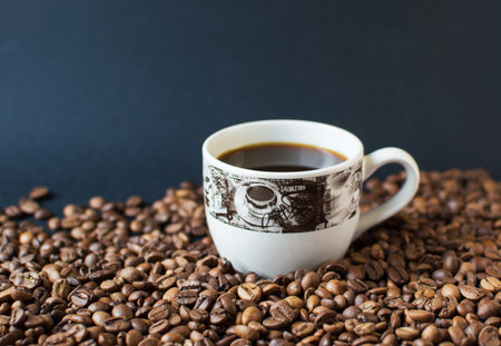cup with coffee on a dark background and scattered grains of coffee. good morning. kind of sveru....