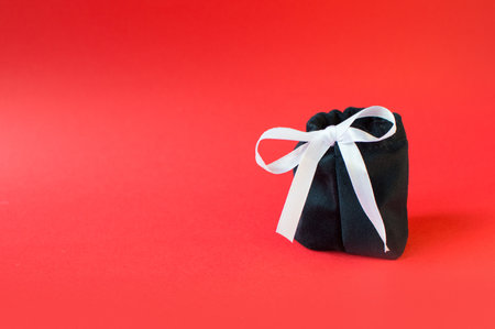 Black Friday - black gift bag with gifts on a red background. Super sale, sales promotion and...