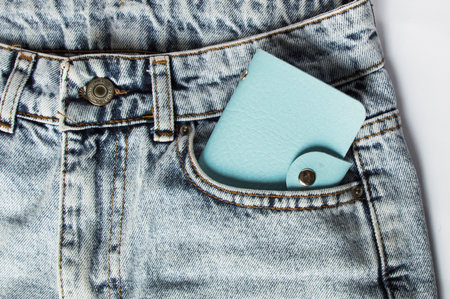 A dollar bill sticking out of a pocket of blue jeans, a credit card, and a wallet. Poverty and unemployment. Concept of financial problems, last money. Cash. Business, trade or financial transactions.の写真素材