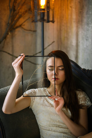 gentle girl posing fooling in vintage view through glassの写真素材