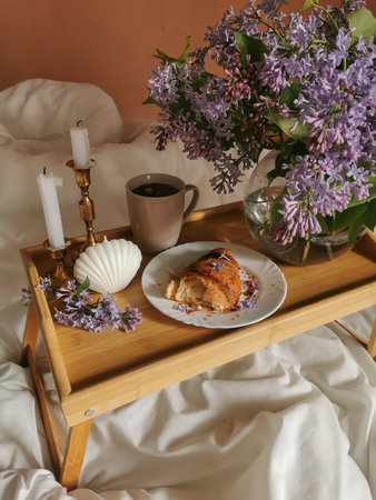 Morning coffee with french croissant, candle in shell form, candels in vintage candlesticks and...