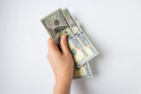 Womans hand holds money 300 dollars for immigration on white background. Because of the war and...